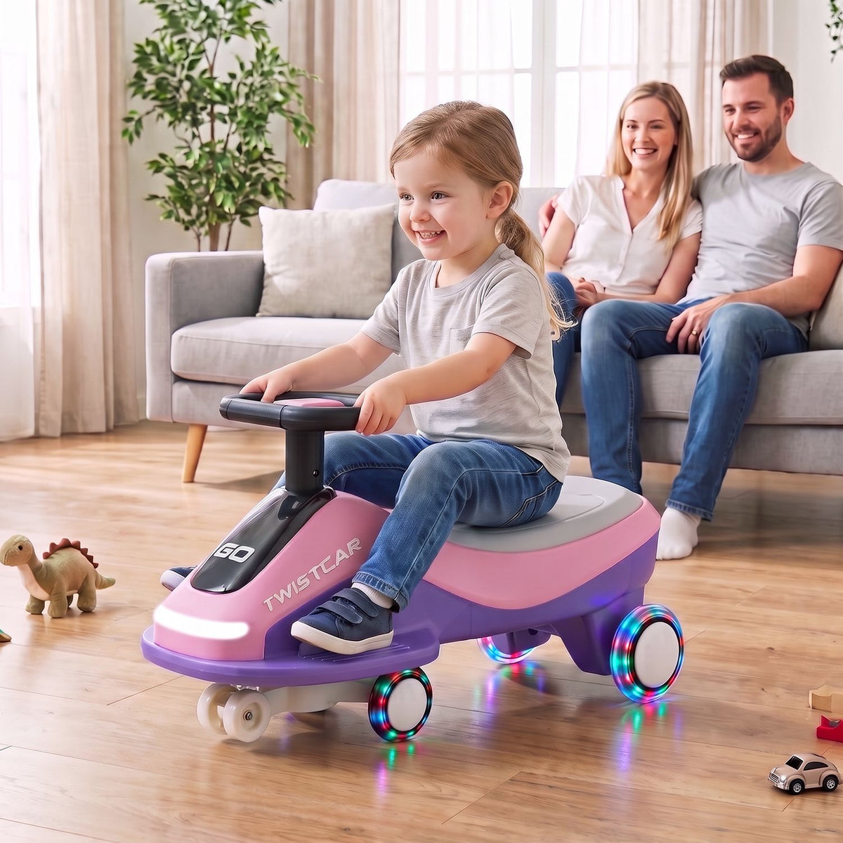 A child rides a pink-and-purple wiggle car indoors while two adults watch from a sofa.