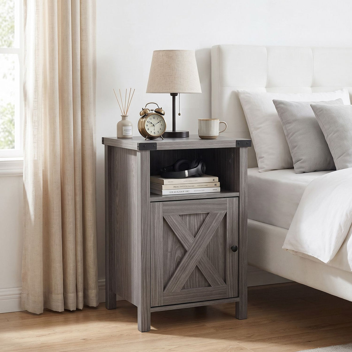 Gray farmhouse nightstand beside a bed, topped with a lamp, alarm clock, and mug.