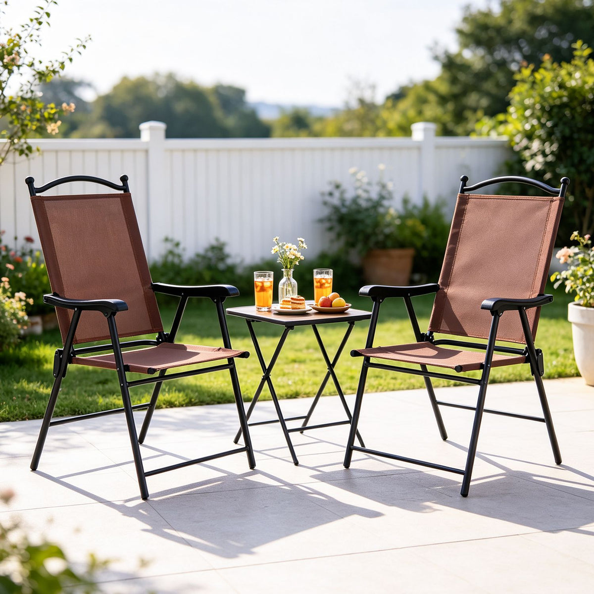 Two brown folding chairs face each other across a small table with drinks and flowers.