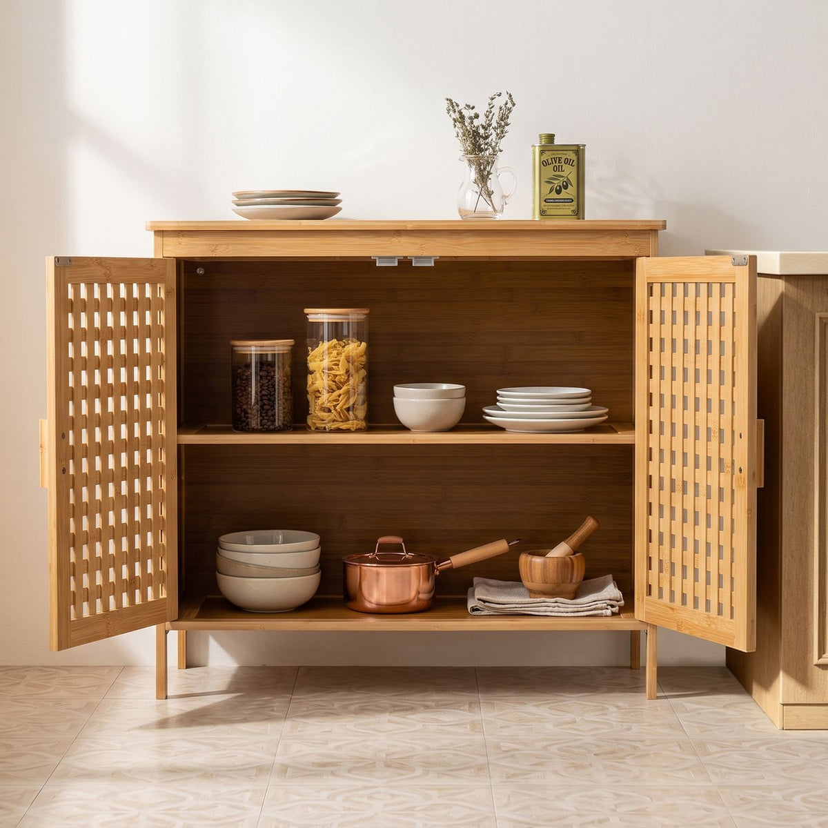 Both lattice doors open to reveal two shelves stocked with dishes, jars, cookware and folded cloths.