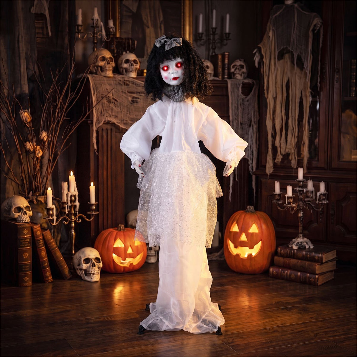 A black-haired doll with glowing red eyes stands in a white gown among candles, skulls, and pumpkins.