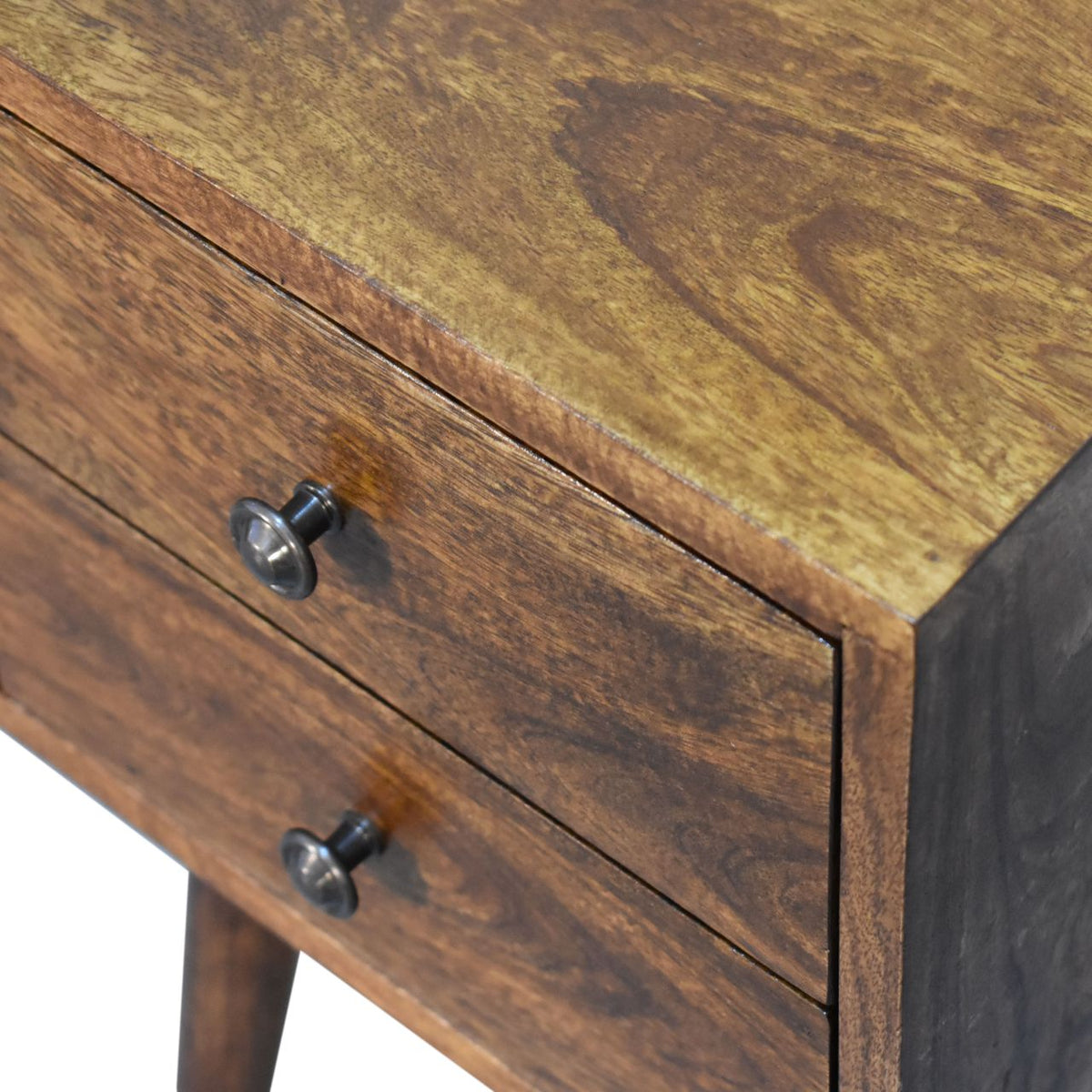 Angled close-up of the chestnut wood top and two drawer fronts