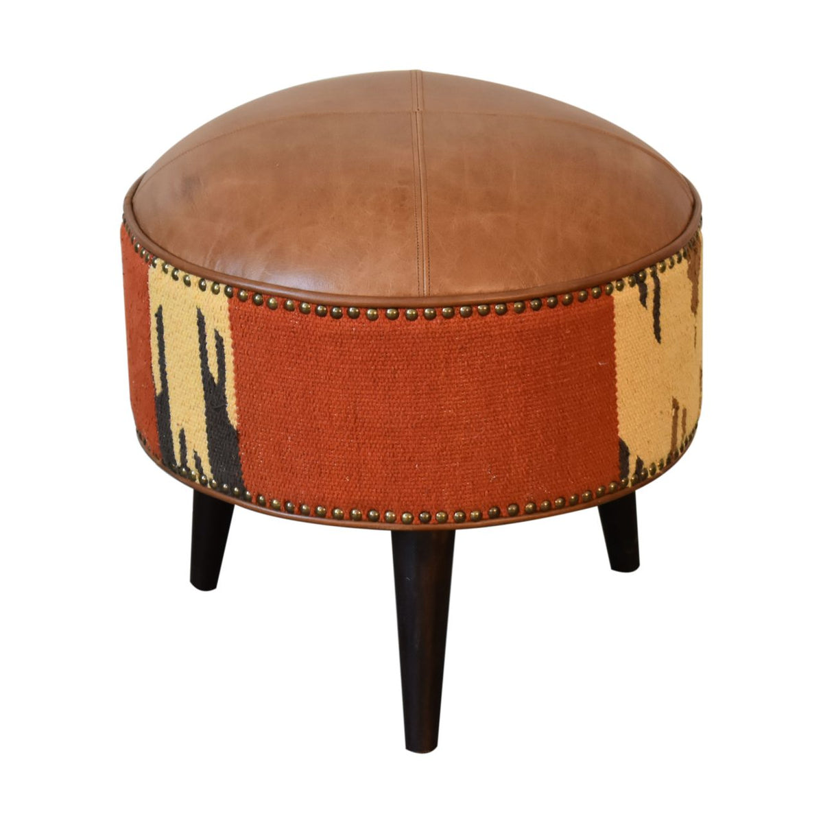 Three-quarter view of a round footstool with tan top, patterned rust sides, and dark legs.