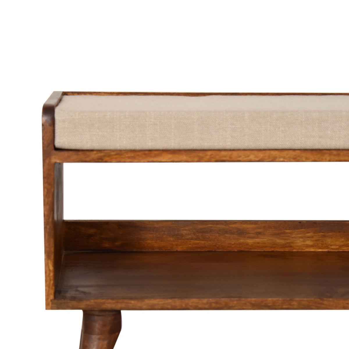 Close view of the beige upholstered seat, chestnut wood frame and open shelf