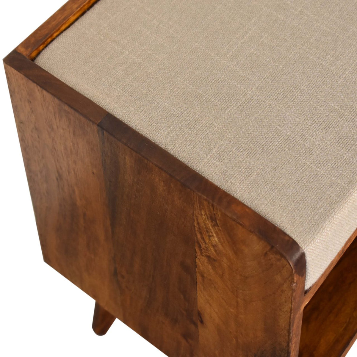 Close angled view of the beige linen seat pad and chestnut wood bench corner