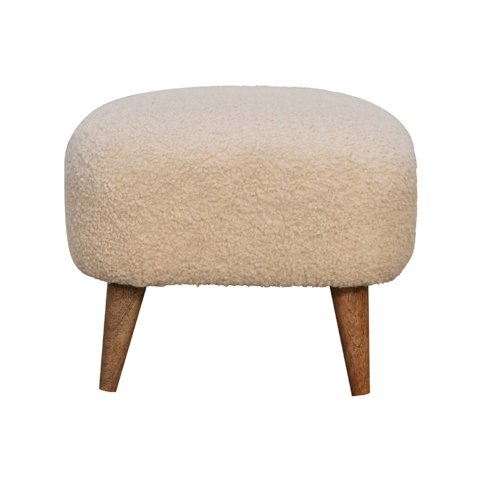 Cream boucle footstool with two tapered wood legs, shown straight on against white