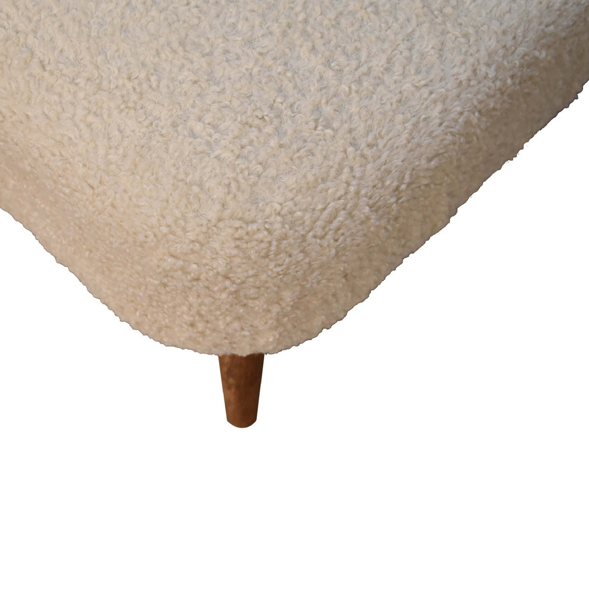 Close detail of the cream looped upholstery and one tapered wood leg