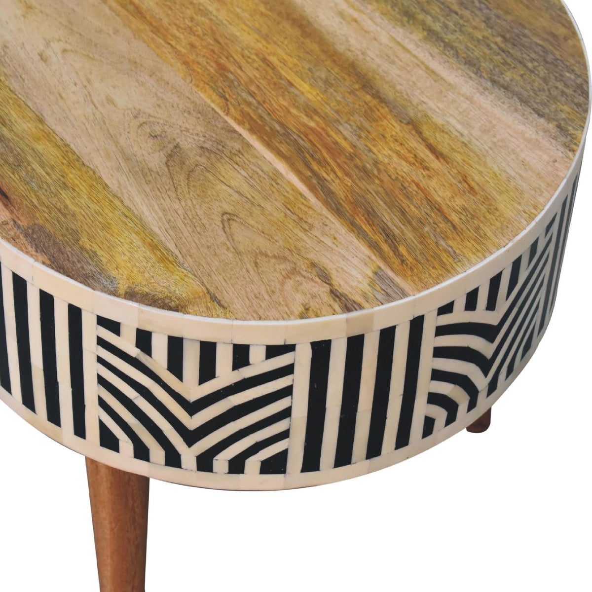 Angled close-up of the light wood tabletop and patterned table edge