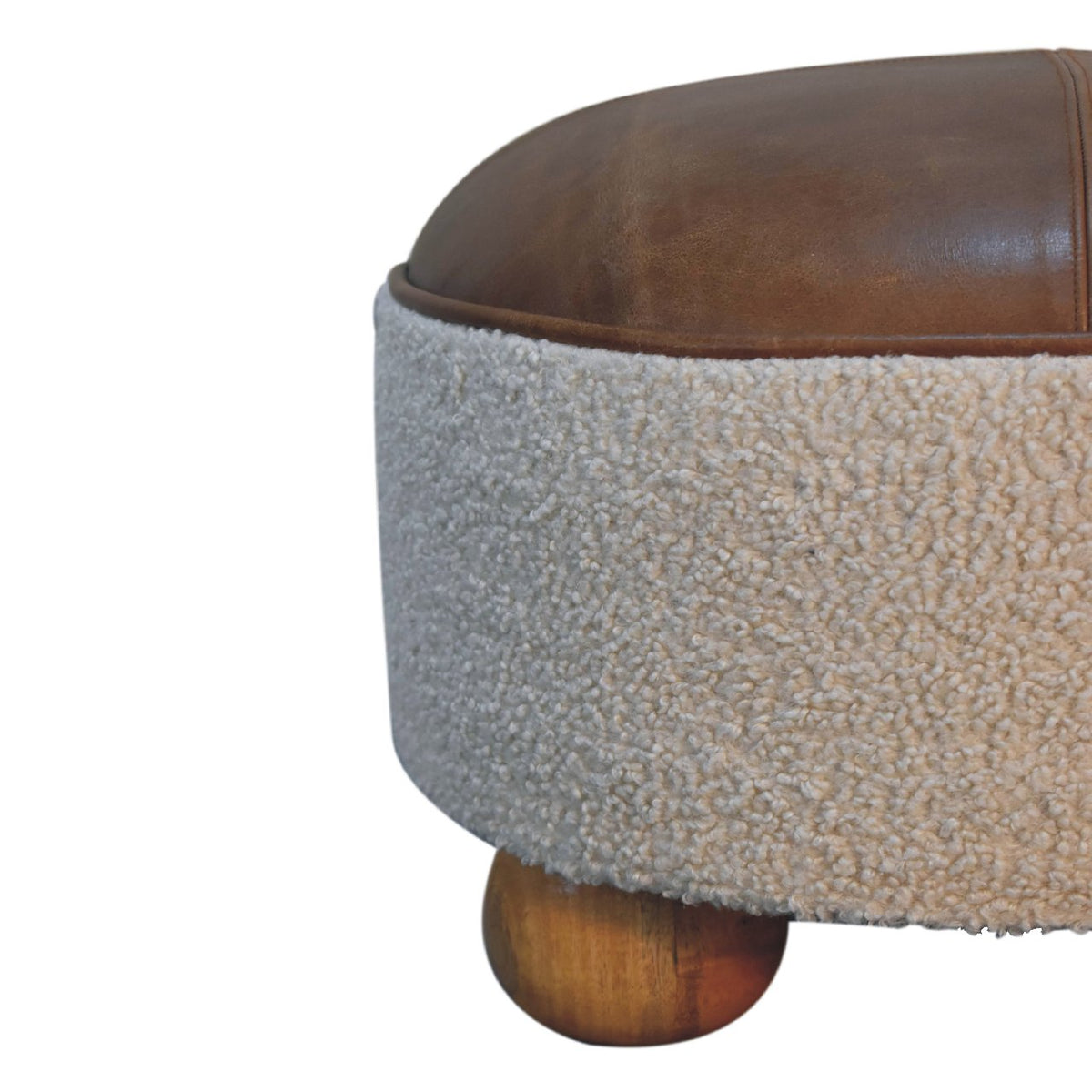 Side close-up of the cream boucle body, brown leather seat and wooden foot