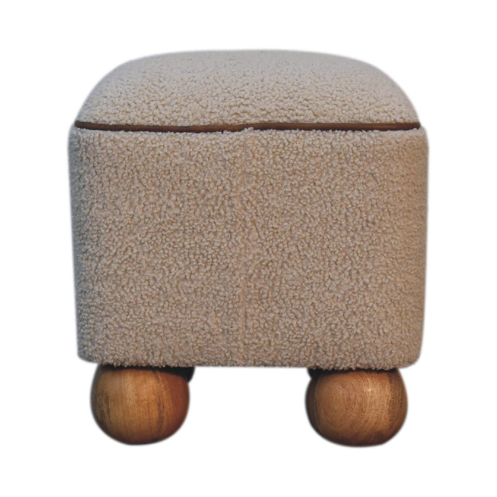 Beige textured footstool with brown piping and wood ball feet, straight-on view