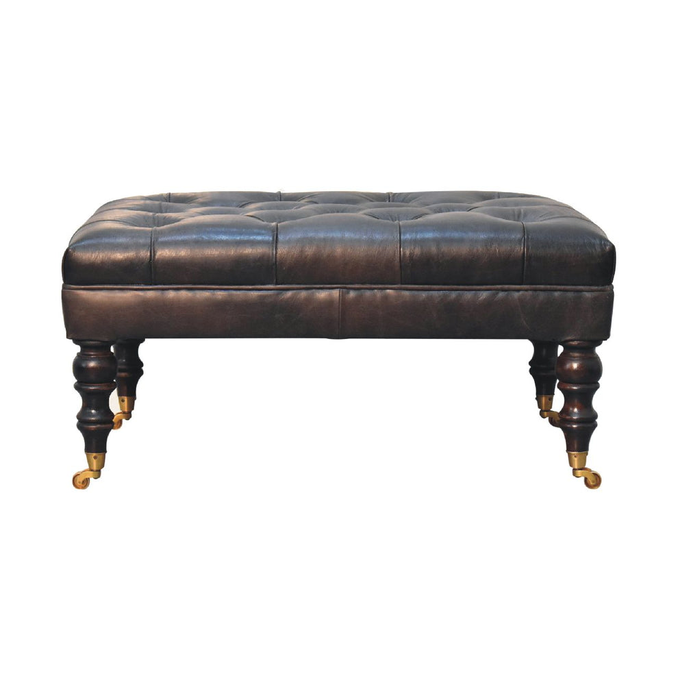 Dark leather deep-buttoned ottoman in a straight-on front view on white
