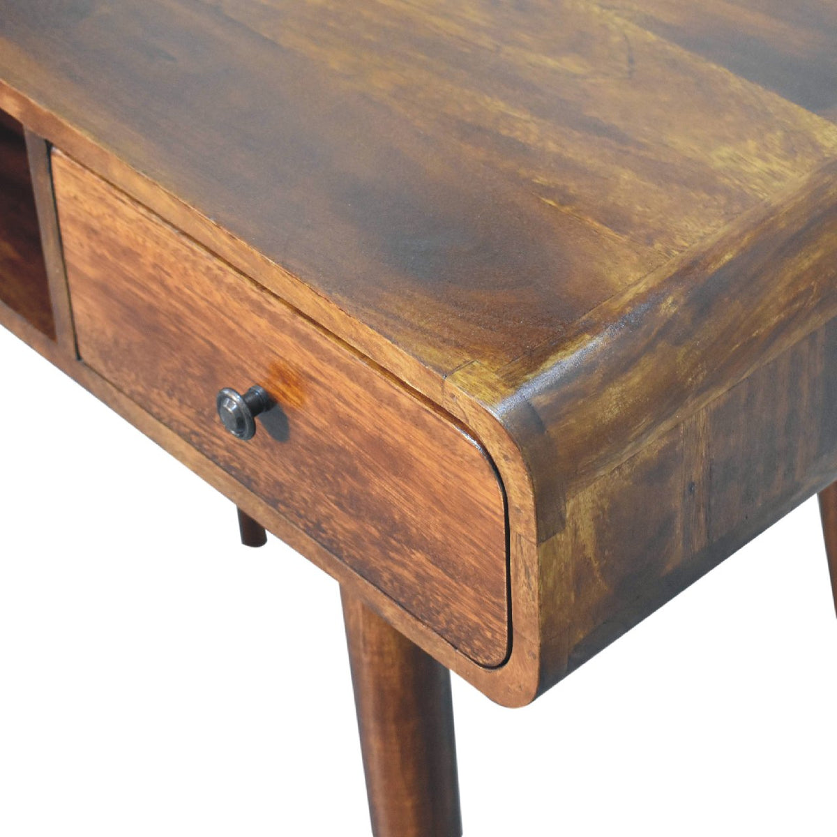 Detail of the chestnut desk's rounded corner, wood grain, drawer front, and leg