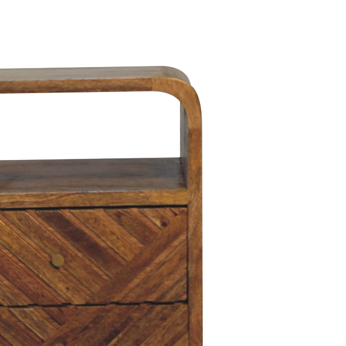 Close-up of the open shelf and carved drawer fronts on a brown wood nightstand