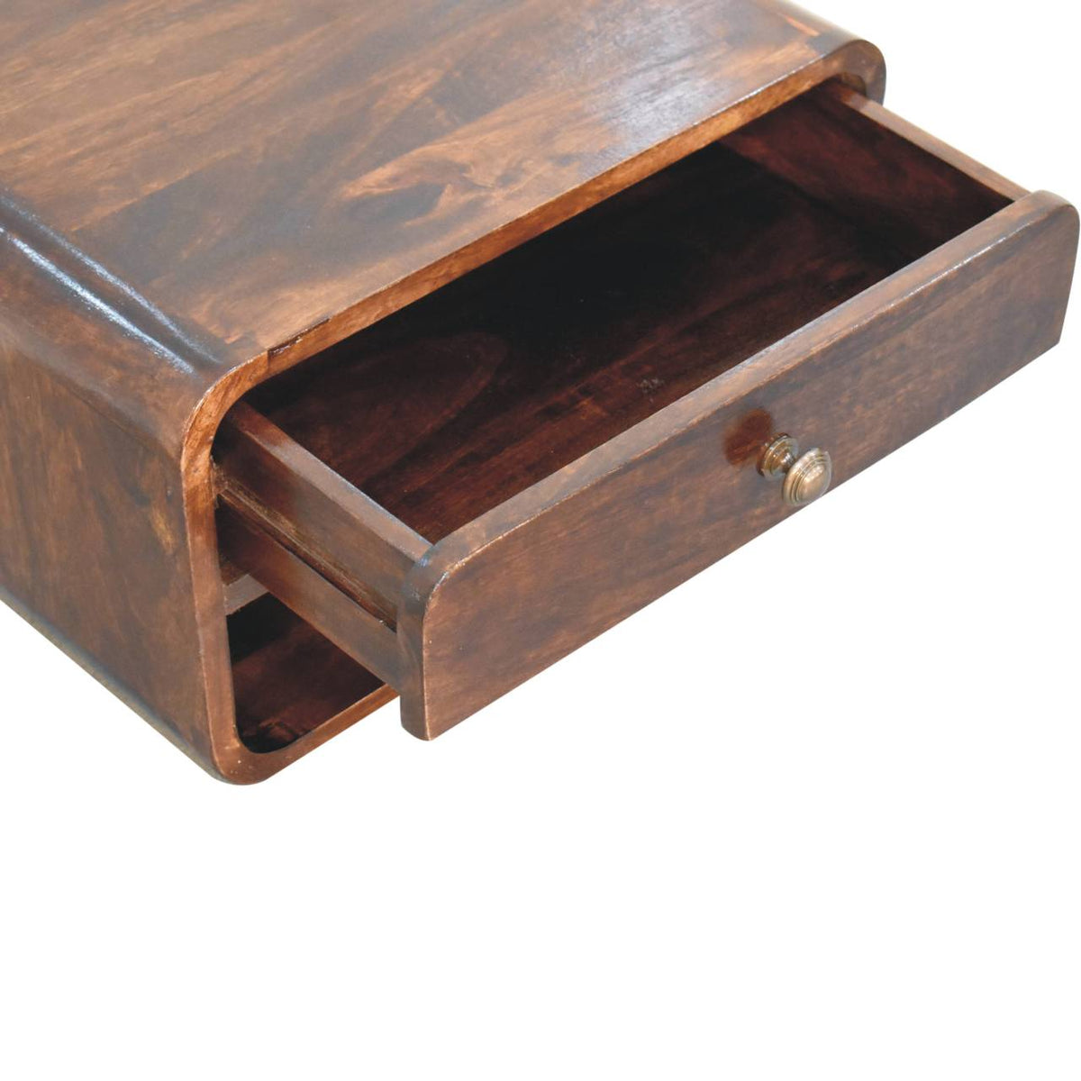 Close-up of the bedside table with its drawer pulled open above the lower open slot.