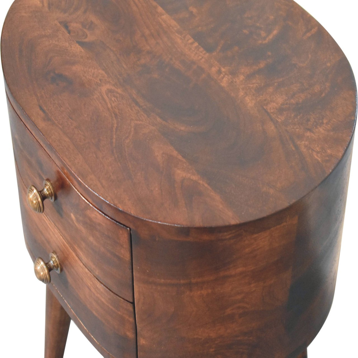 Overhead angled detail showing the rounded tabletop and wood grain of the bedside table