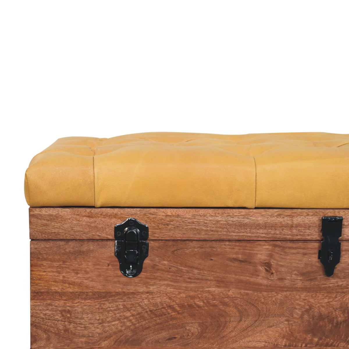 Close-up of the golden upholstered lid edge and black clasp against the wood trunk.