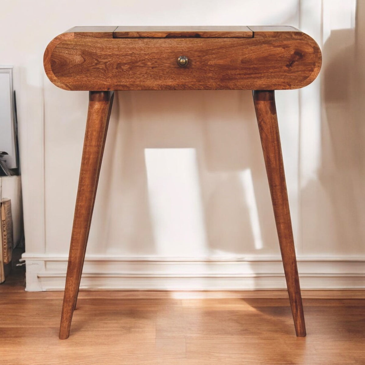 Dressing table with its mirror folded flat, shown against a light wall above a wood floor.