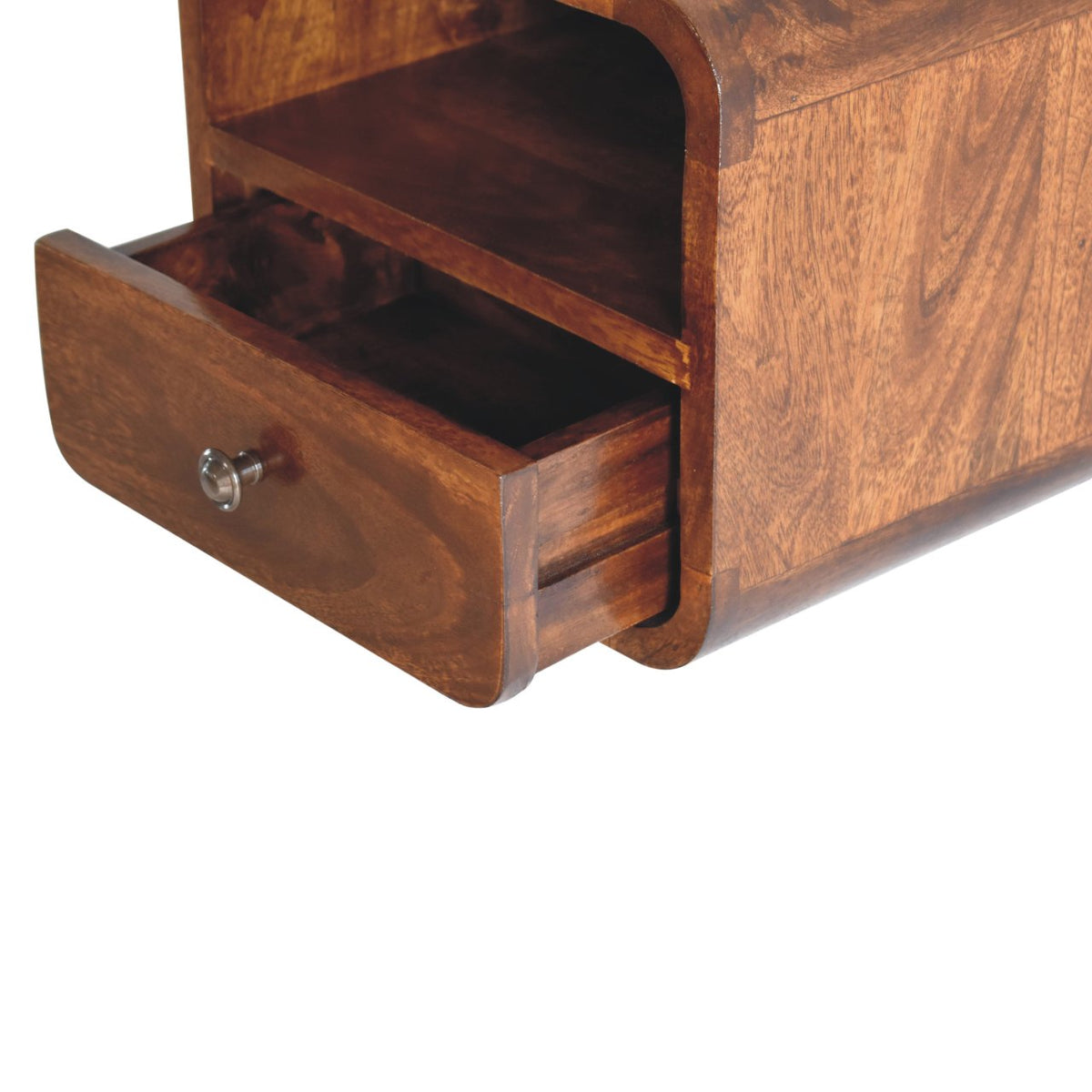An open drawer with a metal knob extends beneath the bedside’s empty curved shelf.