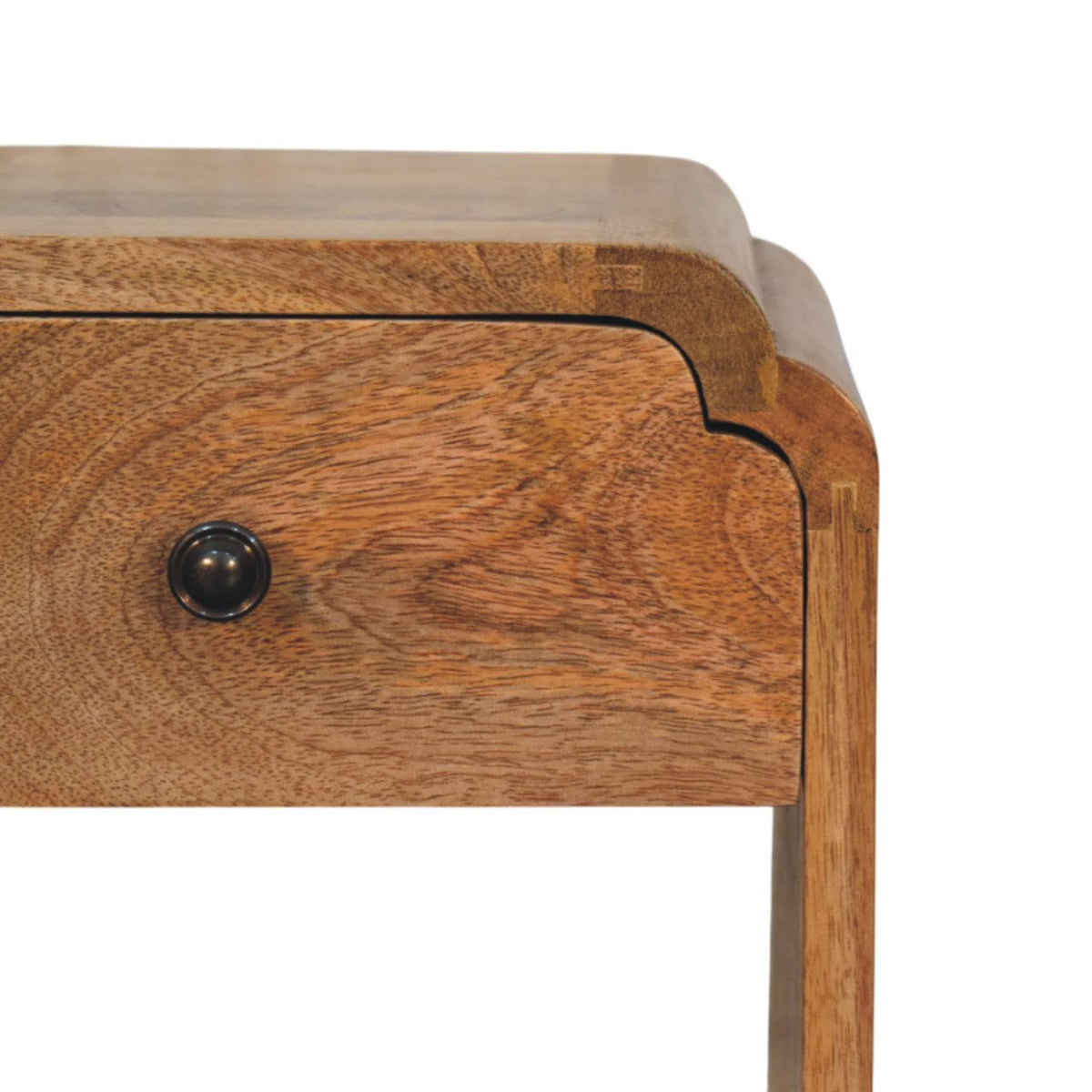 Close-up of the drawer front, dark round knob, wood grain, and rounded top edge.