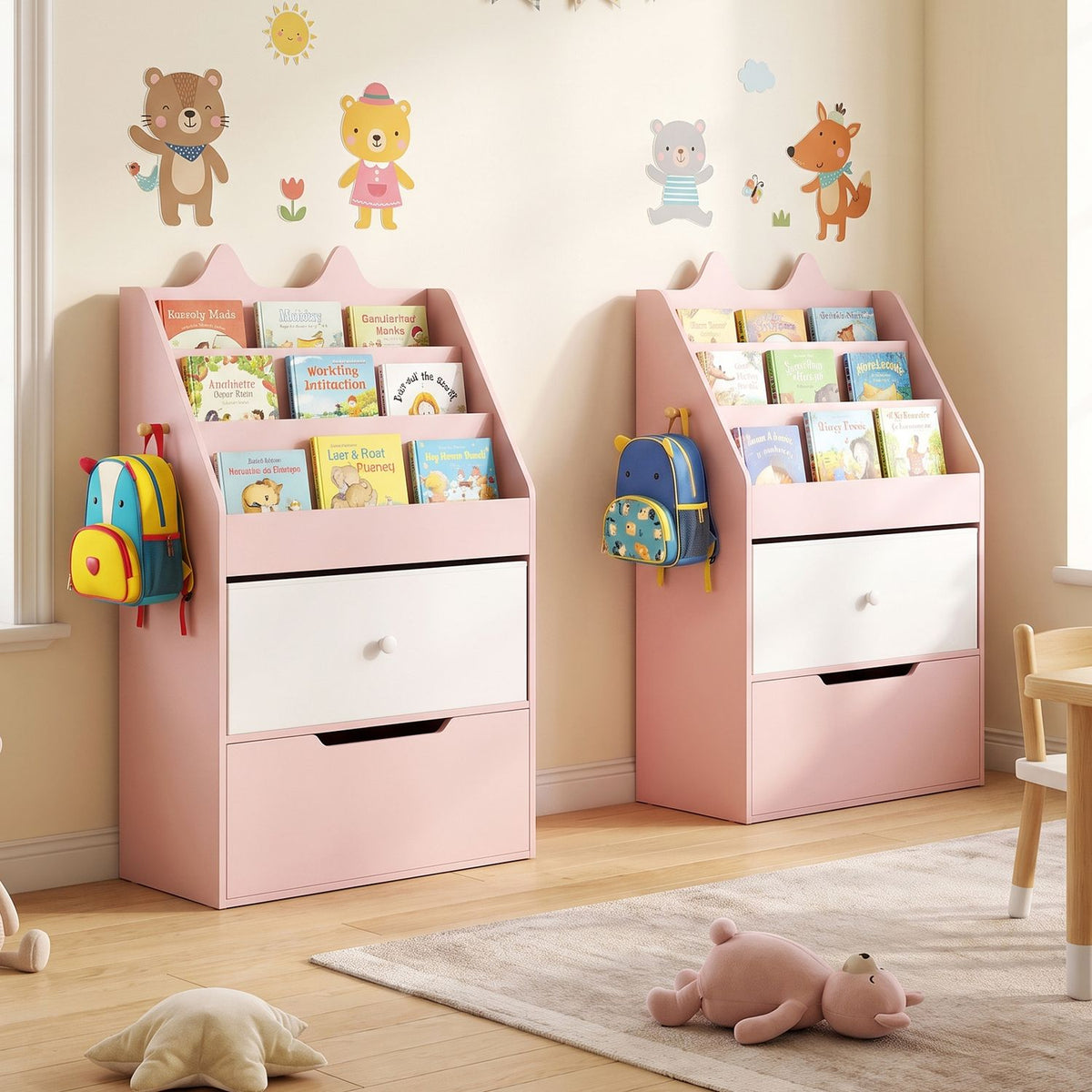 Two pink book and toy organizers filled with books stand against a decorated wall in a child's room.