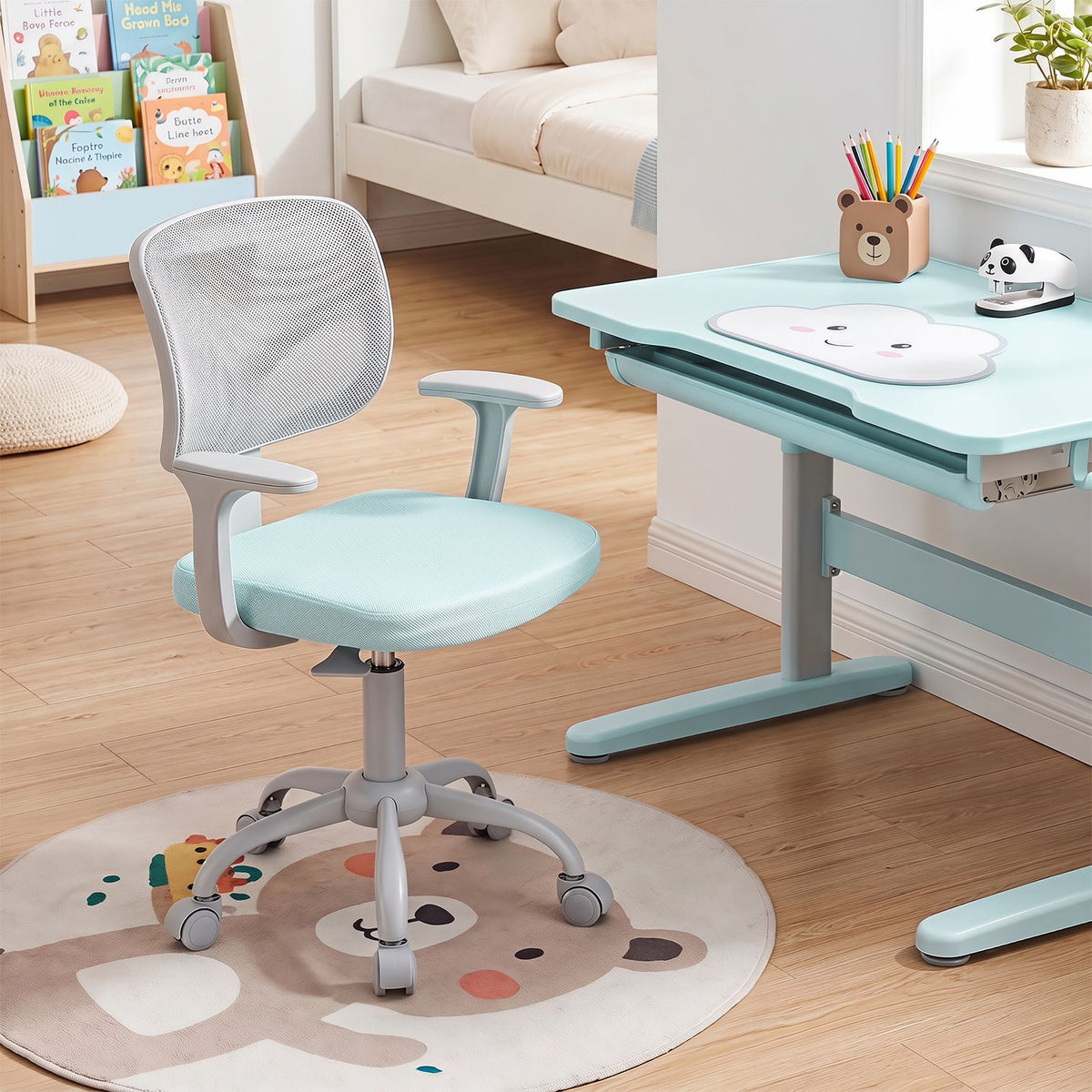 A light blue and gray swivel chair sits beside a child-sized desk in a softly lit bedroom.