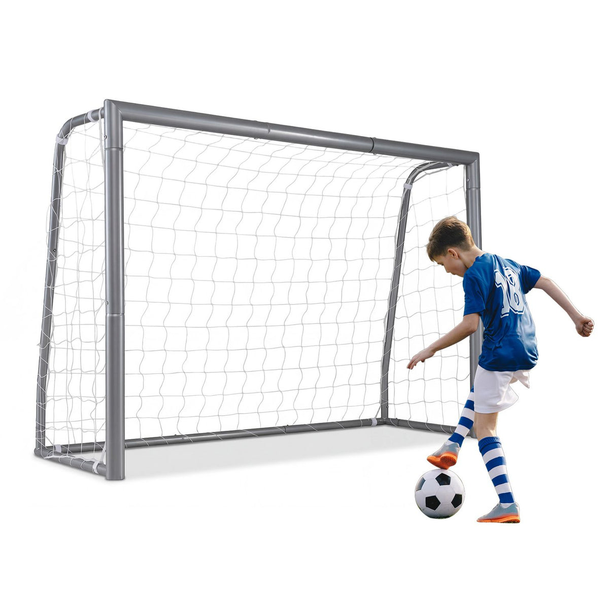 A child in a blue jersey kicks a soccer ball beside a netted metal goal.