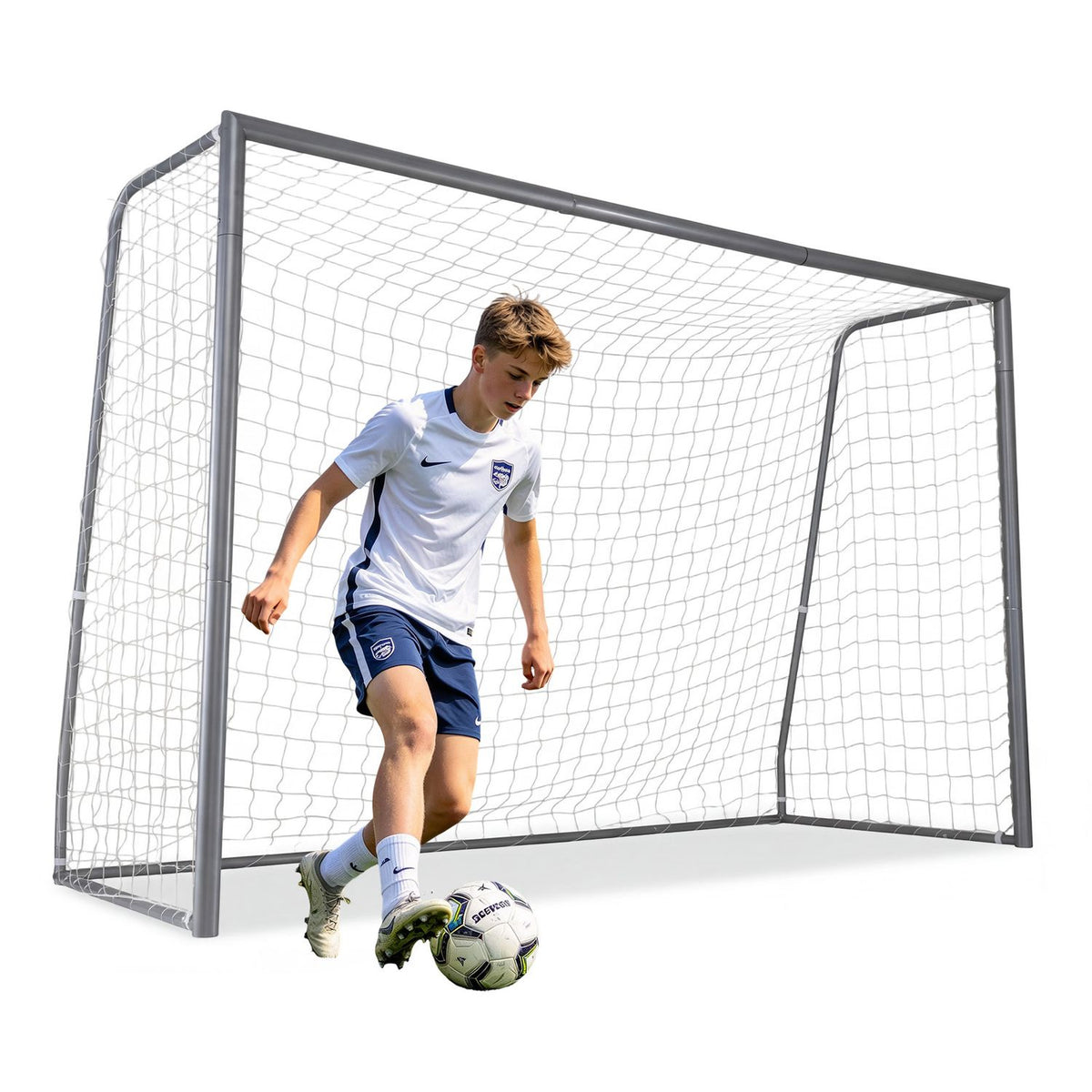 A young player dribbles a soccer ball in front of the goal and net.