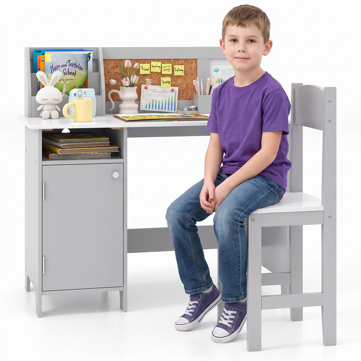 A child in a purple shirt sits on the matching chair beside the gray desk.