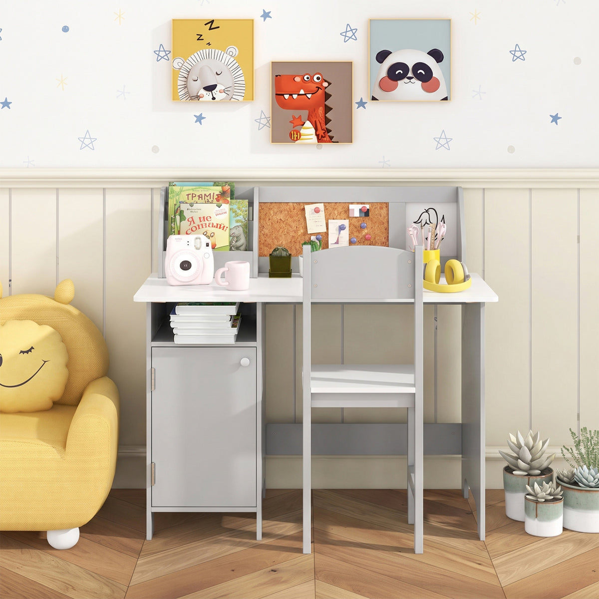 Gray children's desk and chair arranged in a bright room, with books and accessories on the desktop.