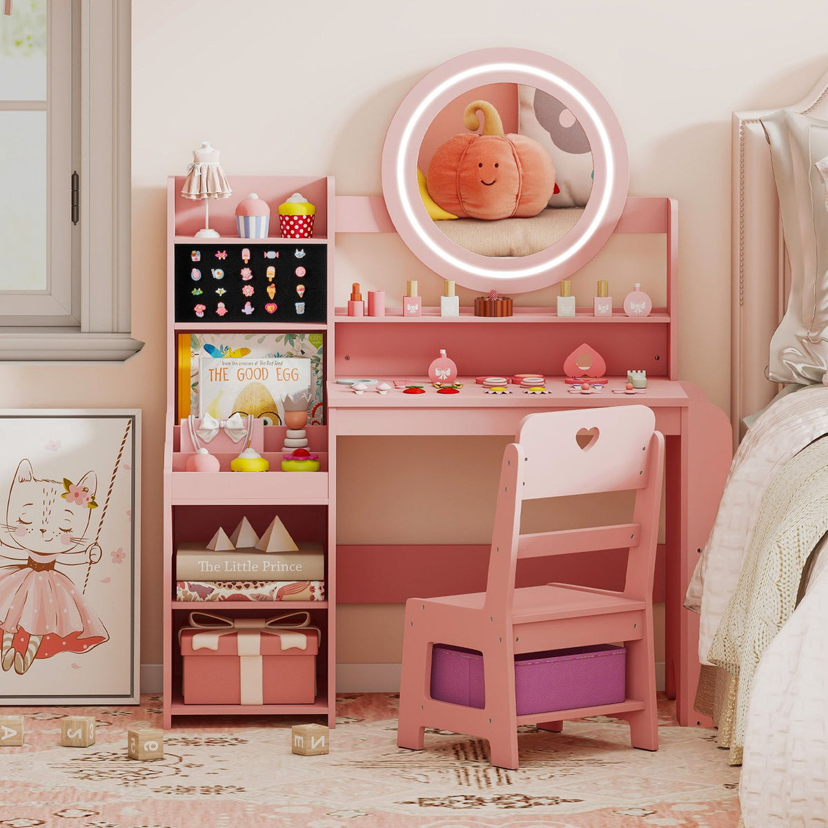 Pink vanity and chair with a glowing round mirror, bookcase, cosmetics, and books beside a bed.