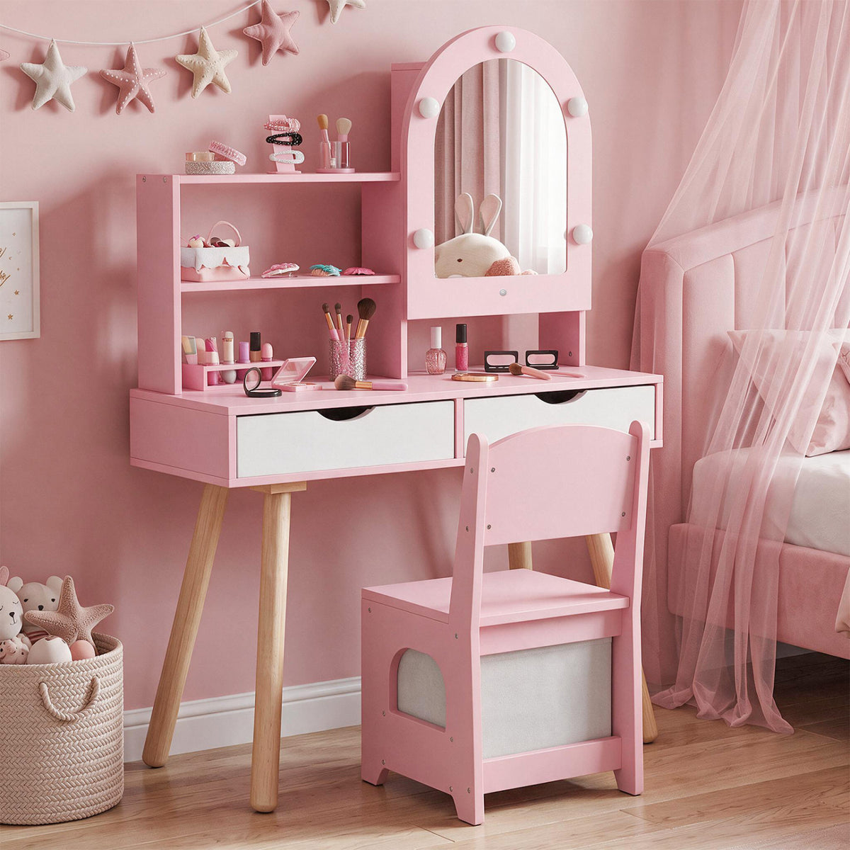 Pink vanity set and matching chair in a softly decorated bedroom, with toys and accessories on the shelves.