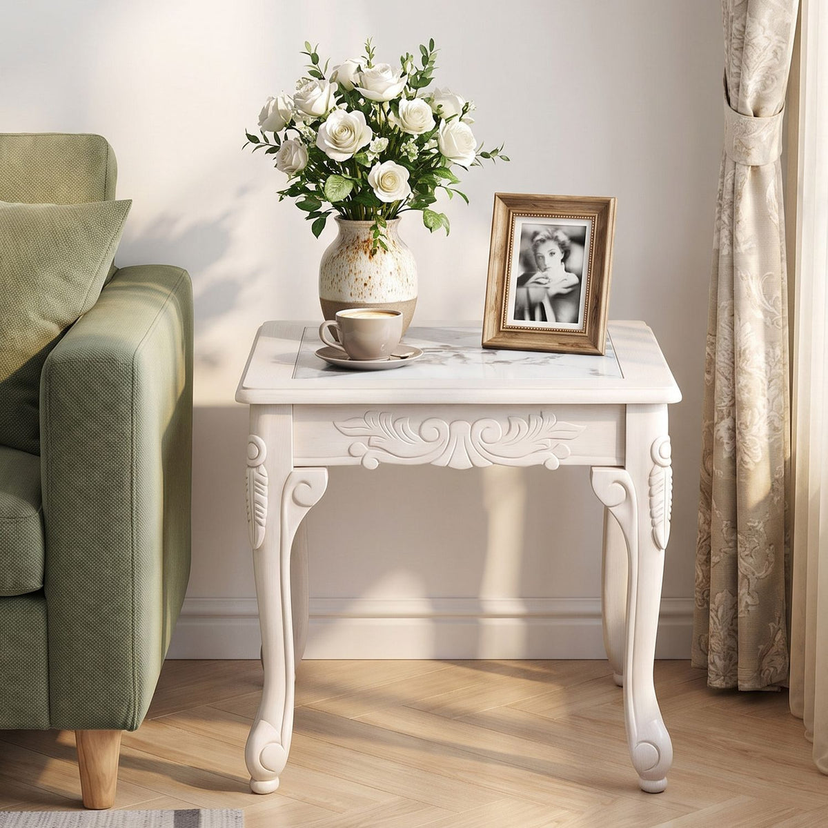 White carved coffee table beside a green sofa, viewed from the front