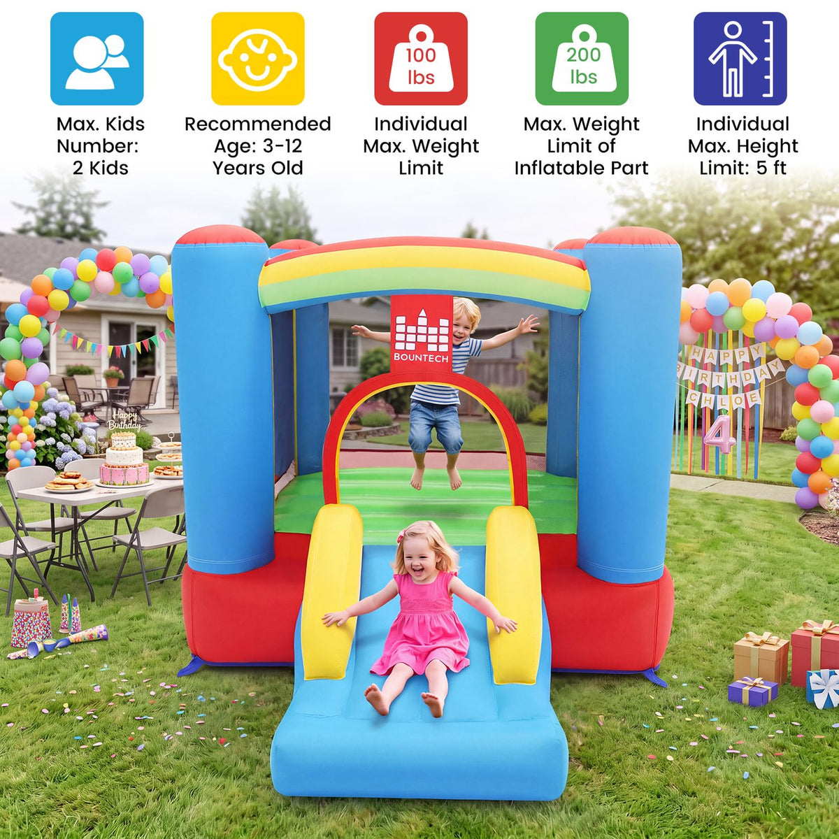 Two children play on a rainbow-colored inflatable bounce house in a decorated backyard.