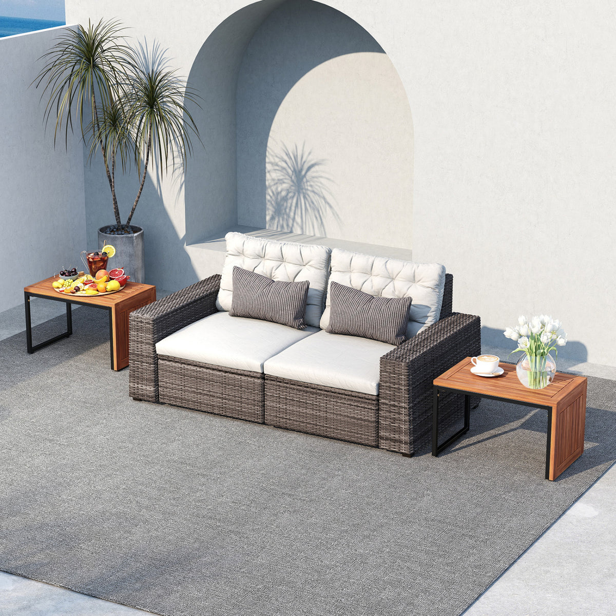 Two wood-and-metal side tables flank a cushioned outdoor loveseat.