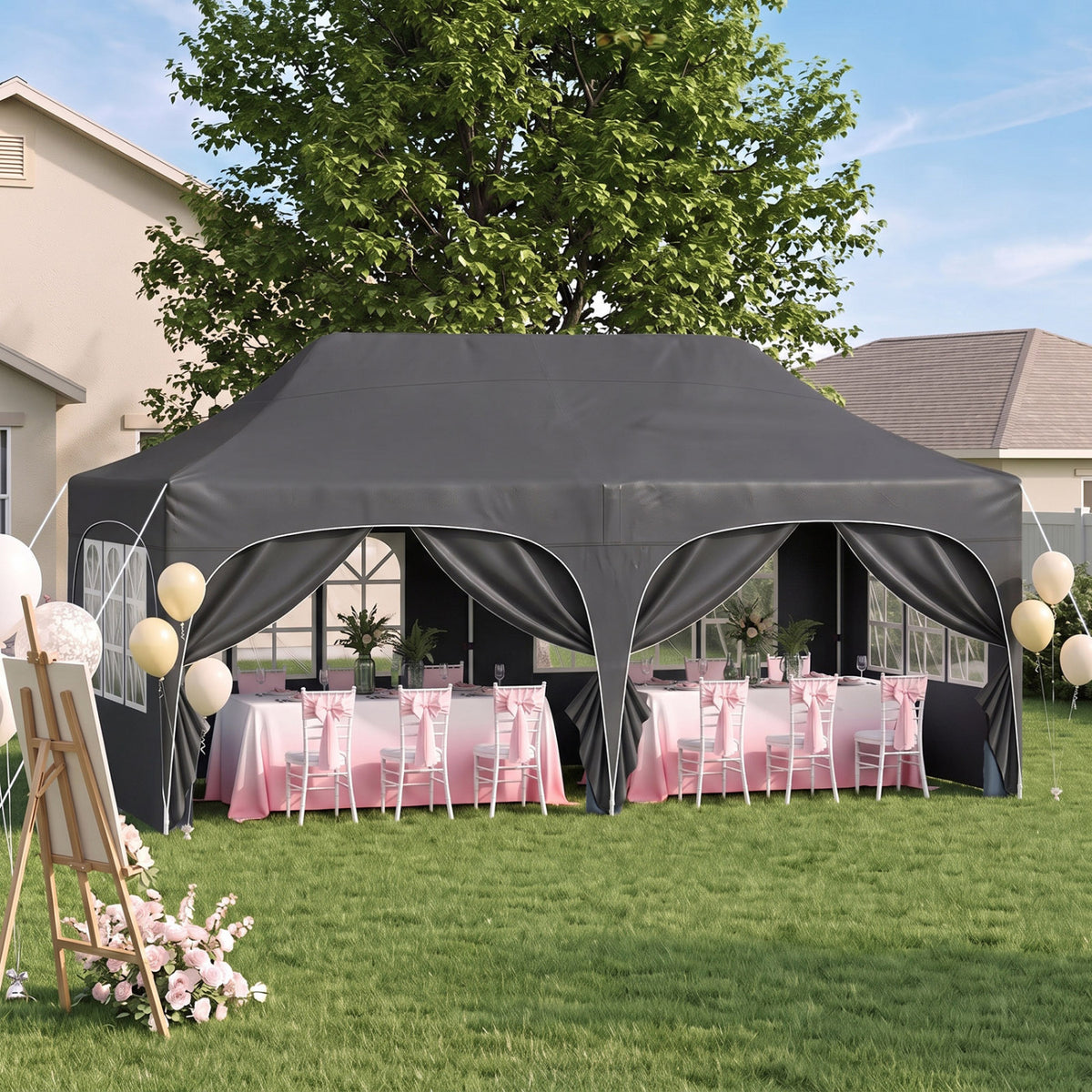 A dark gray canopy tent with tied-back side panels shelters pink-decorated banquet tables on a lawn.