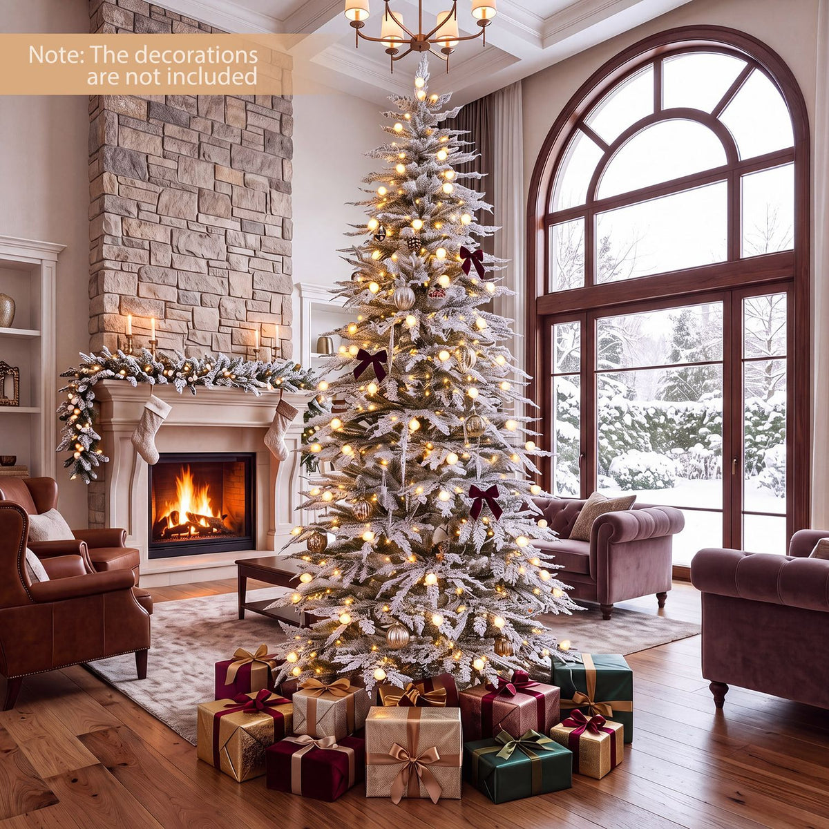 Flocked Christmas tree glowing with warm lights beside a fireplace and arched window, with gifts beneath it.