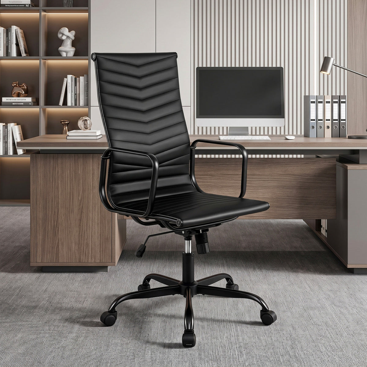 Black high-back chair with ribbed upholstery in a modern office with a desk and monitor.
