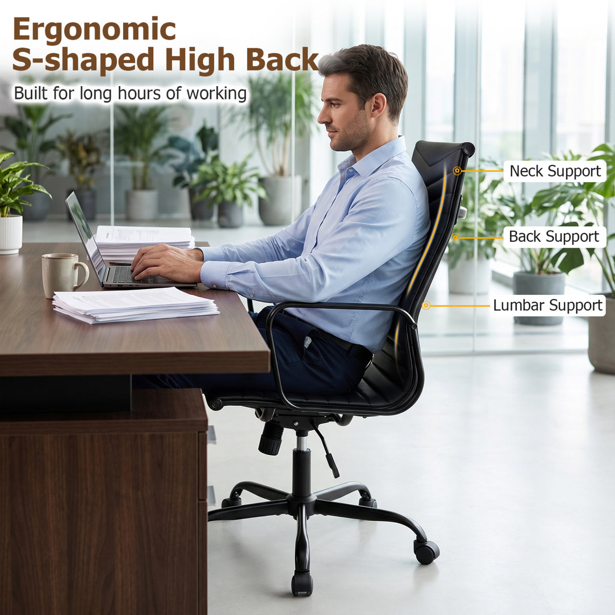 A man works at a desk while seated in a black high-back office chair with curved armrests and a wheeled base.