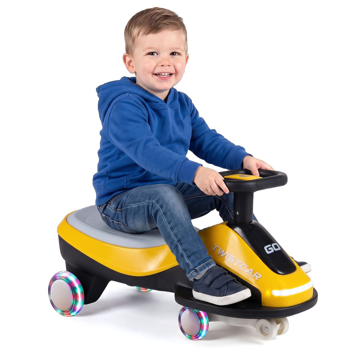 A child sits on the yellow and black ride-on car against a plain white background.