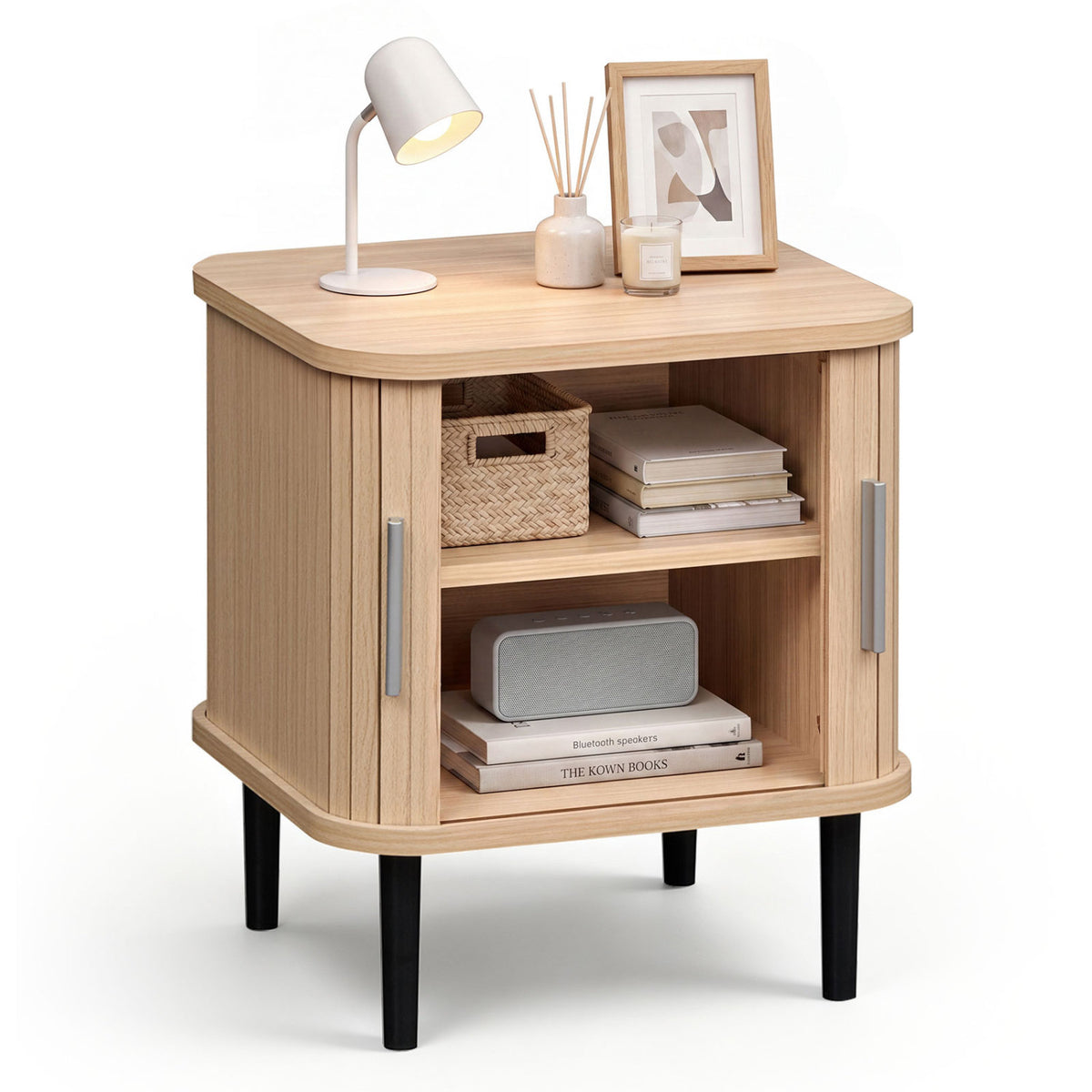 Nightstand shown with sliding doors open, two shelves holding baskets, books, and a speaker.