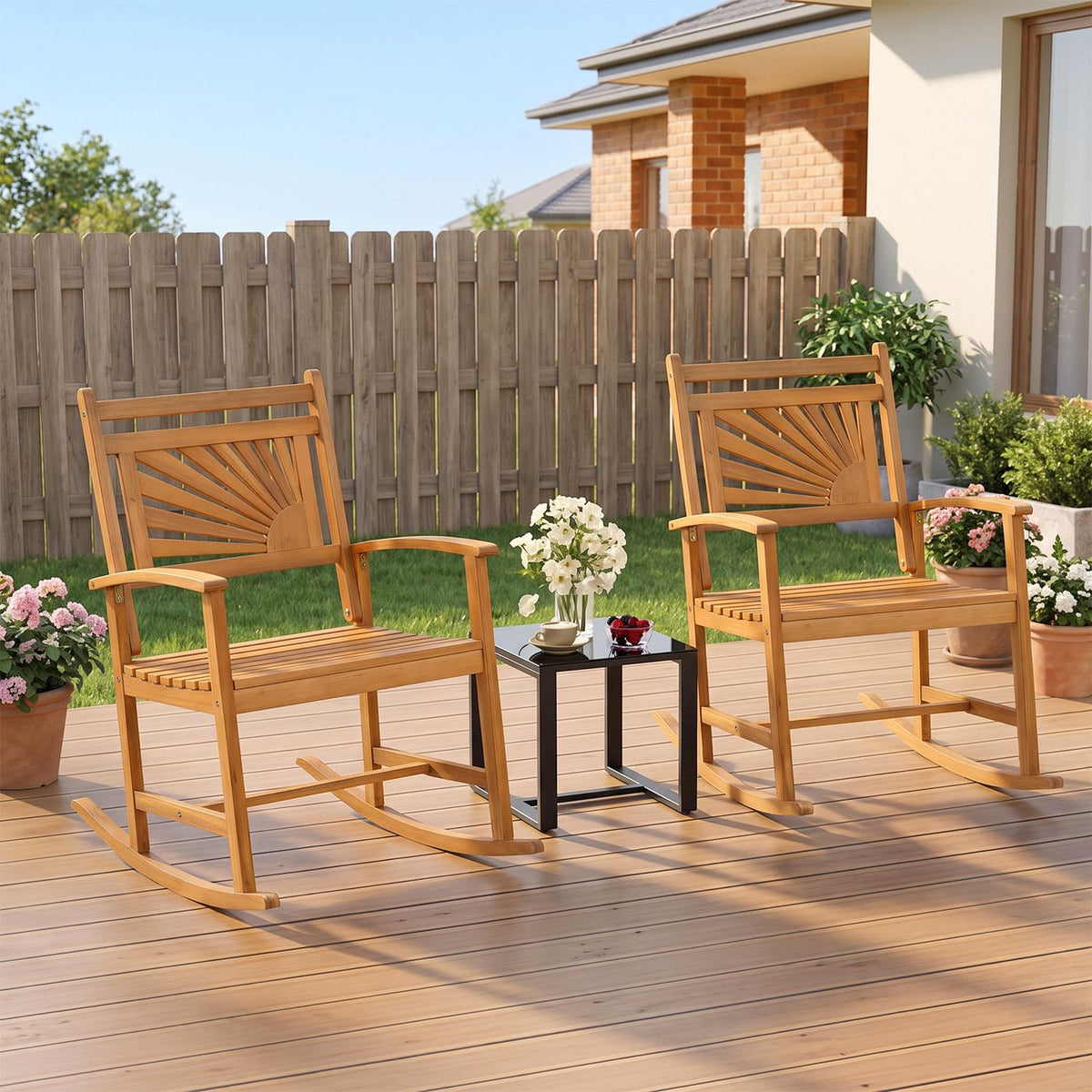 Pair of wooden rocking chairs on a deck beside a small table and garden fence.