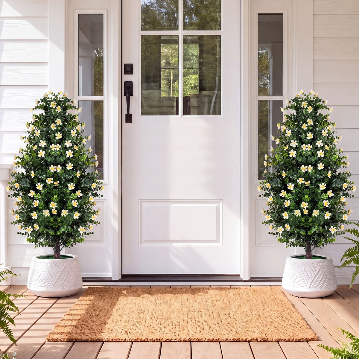 Pair of flowering artificial topiary trees in white pots beside a front door