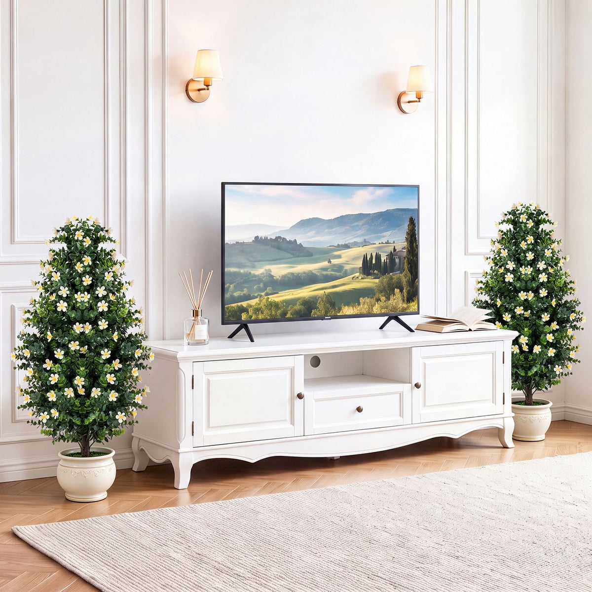 Pair of flowering artificial topiary trees flanking a white living room console