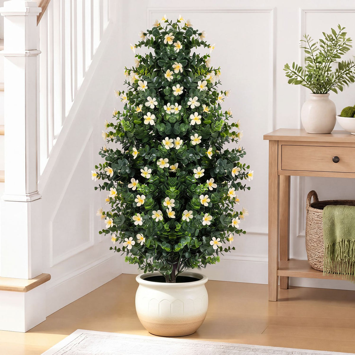 Single flowering artificial topiary tree in a light-colored pot by a staircase