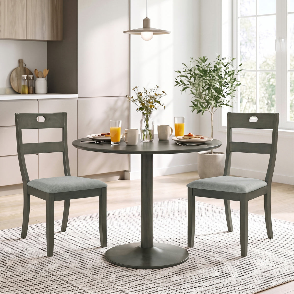 Two gray wooden dining chairs with padded seats sit beside a round table in a bright dining area.