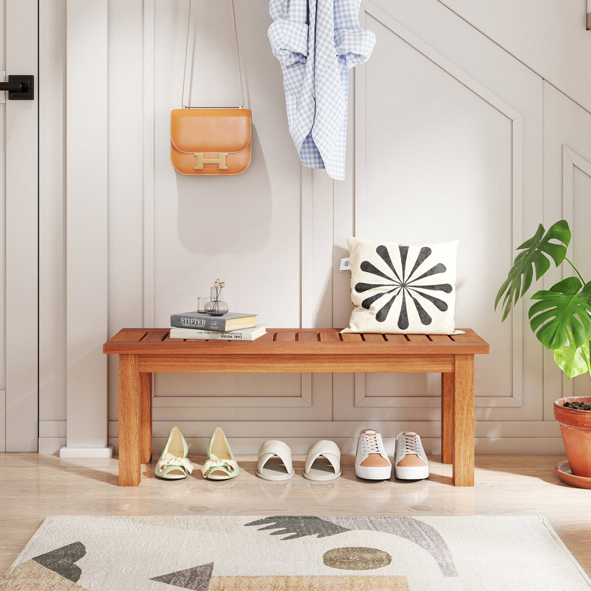 Wooden slatted stand in an entryway, styled with books and a cushion on top and shoes underneath.