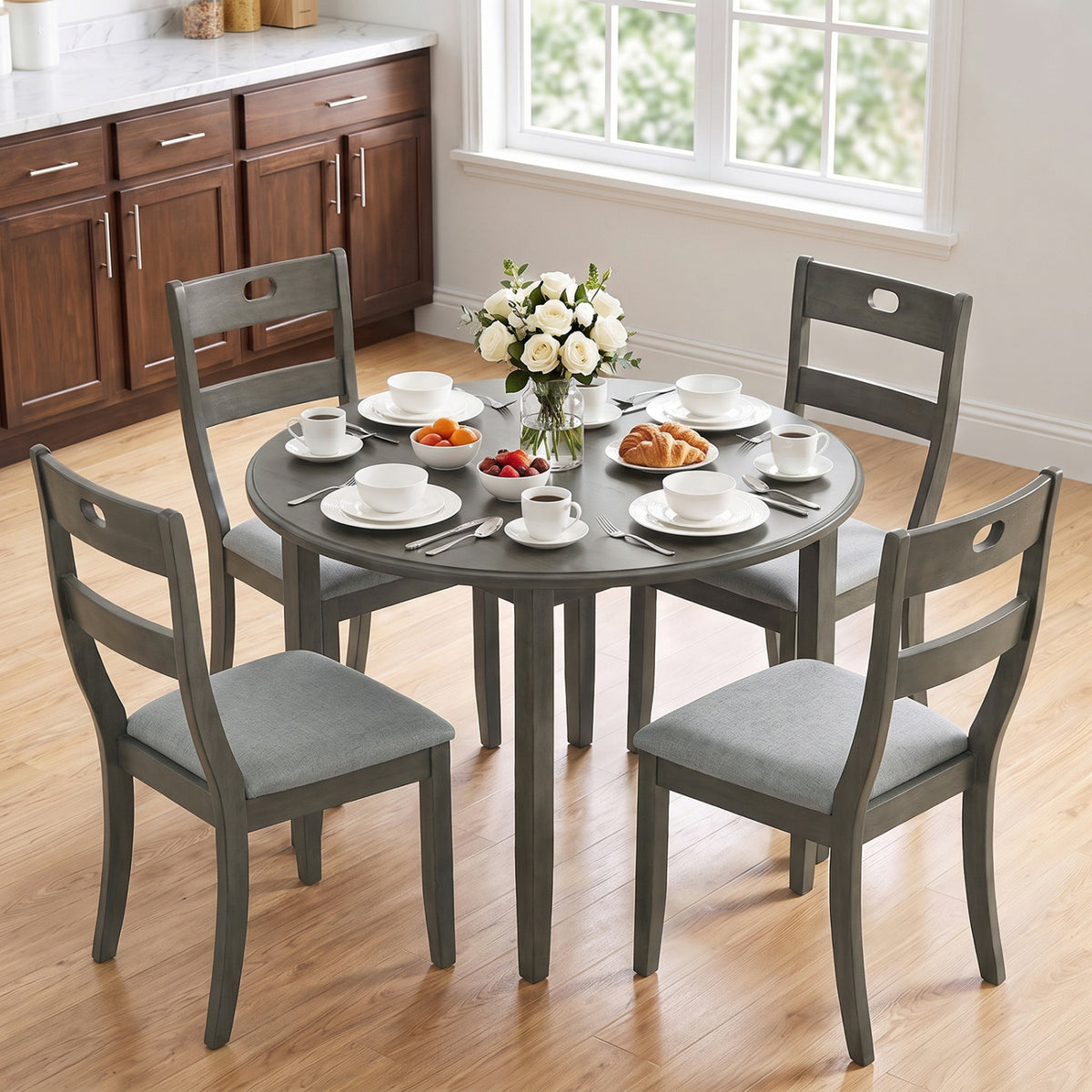 Four gray wooden chairs with padded seats arranged around a set dining table.
