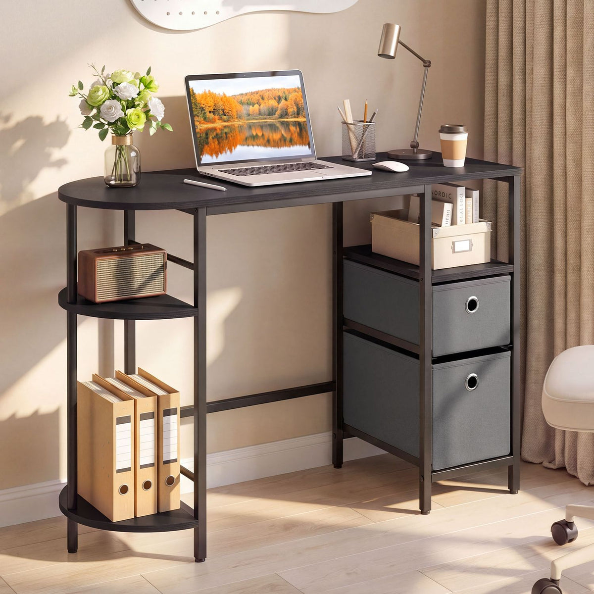 Black desk with rounded side shelves and two fabric drawers, styled with a laptop, flowers and desk accessories.
