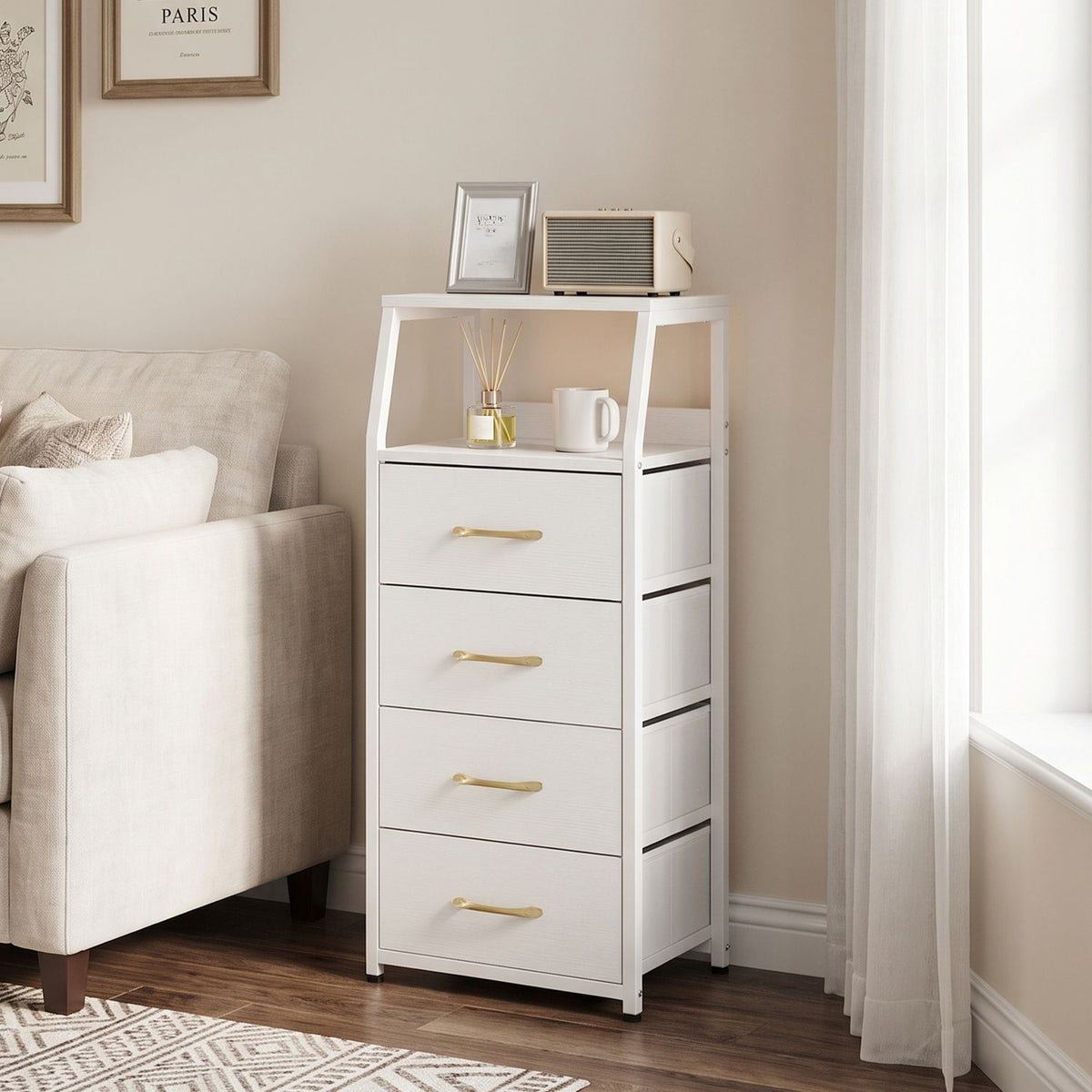 White fabric-front dresser with four gold-tone handles and an open shelf, styled beside a sofa.
