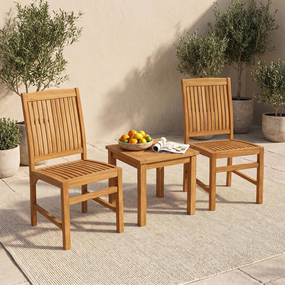 Two slatted wooden chairs beside a small table on an outdoor rug.
